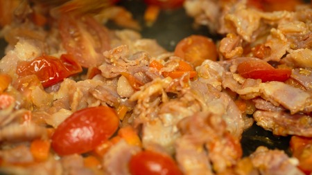 tomatoes bacon onion carrots in a pan closeupの写真素材