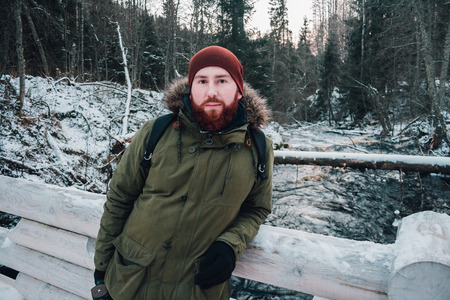 bearded hipster outdoors in winter. Portrait of a bearded man in a winter forestの写真素材