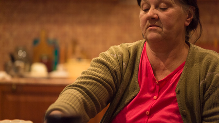 An elderly woman is sad on the tableの写真素材