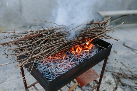 Burning dry branches in the brazier. Photo in the daytime.の写真素材