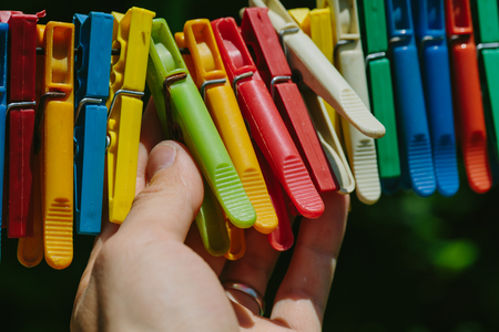 Group of colored clothespins that a man holds. Photo in the daytime.の写真素材