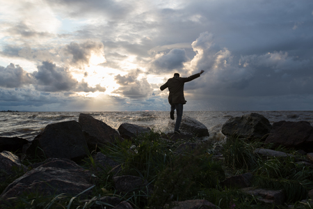 man by the sea in stormy weatherの写真素材