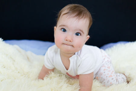 Beautiful blue eyed little baby on the bed.の写真素材