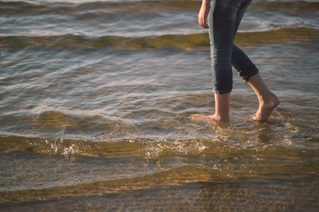 young girl walking along the beach seaの写真素材