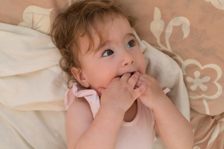 little child put his fingers in his mouthの写真素材