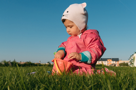 small child playing sitting on a lawn in autumn.の写真素材