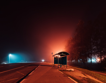 bus stop on a foggy autumn night.の写真素材