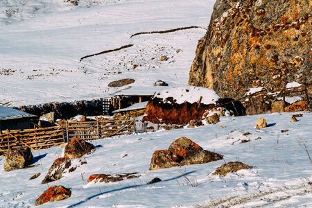 farm in a rocky and snowy area covered with snowの写真素材