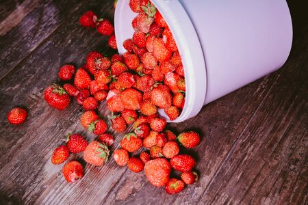 sprinkled natural and fresh strawberry from a white bucketの写真素材