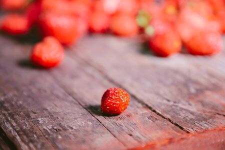 strewn strawberries on an old wooden table