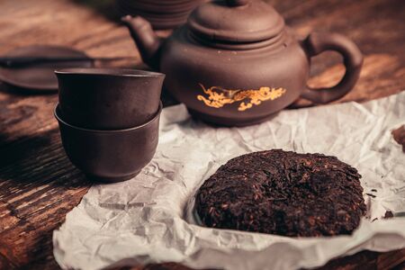 Chinese tea set and accessories made of yixing clay on an old wooden tableの写真素材
