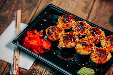 served baked rolls in a black plate on a wooden backgroundの写真素材