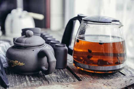 Chinese tea set and accessories made of yixing clay on an old wooden tableの写真素材