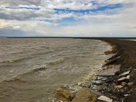 dirty sea and sky near the road in the daytimeの写真素材