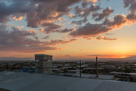 photo of the sunset and clouds as well as the infrastructure of the small town