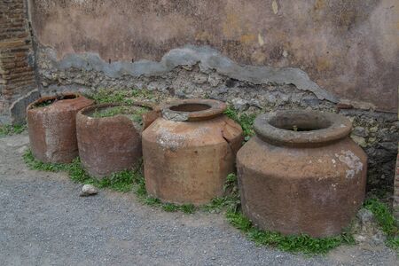 old and rusty barrels on the street covered with mossの写真素材