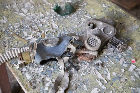 two old and battered gas masks in dust and debrisの写真素材