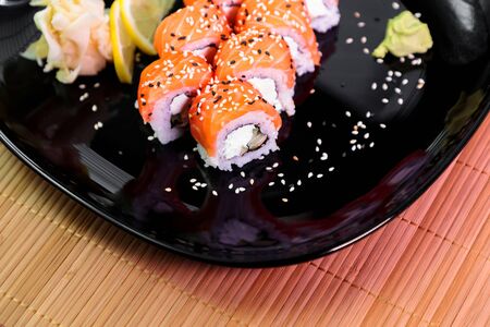 photo of Japanese rolls in a black plateの写真素材