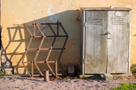 rusty metal box next to an abstract grilleの写真素材