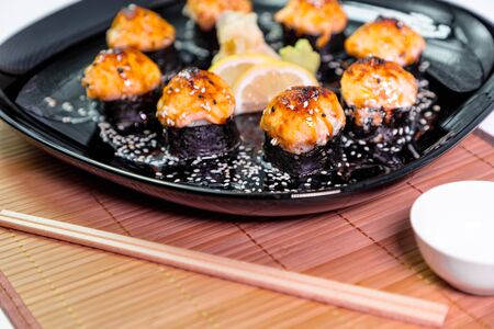 photo of baked Japanese rolls in a black plateの写真素材