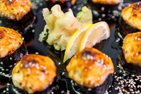 photo of baked Japanese rolls in a black plateの写真素材