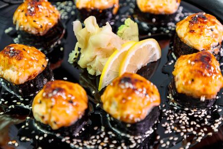 photo of baked Japanese rolls in a black plateの写真素材