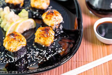 photo of baked Japanese rolls in a black plateの写真素材