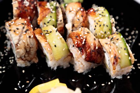 photo of Japanese rolls in a black plateの写真素材