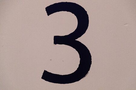 black number 3 on a light wallの写真素材