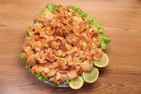 Fried Shrimp in batter on plates with lemonの写真素材