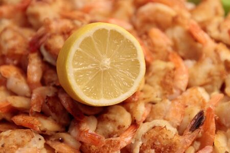 Fried Shrimp in batter on plates with lemon close-upの写真素材