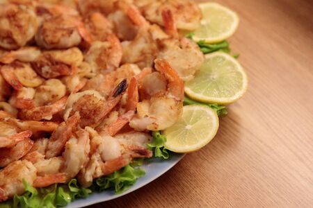 Fried Shrimp in batter on plates with lemonの写真素材