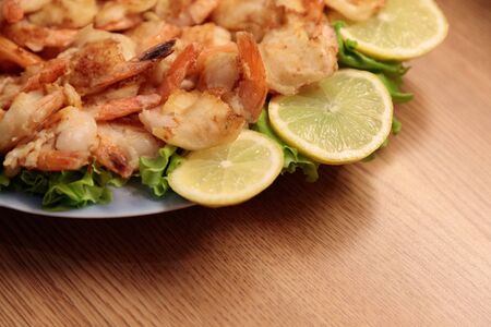 Fried Shrimp in batter on plates with lemonの写真素材