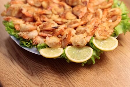 Fried Shrimp in batter on plates with lemonの写真素材