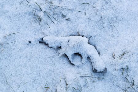 childrens toy gun under the snow top viewの写真素材