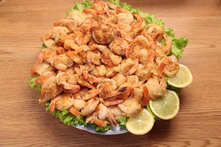 Fried Shrimp in batter on plates with lemonの写真素材
