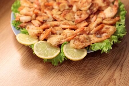 Fried Shrimp in batter on plates with lemonの写真素材