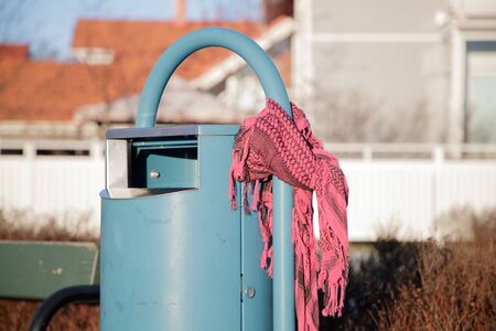 scarf near a garbage can in the park in winter