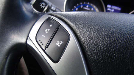 Modern black steering wheel with multifunction buttons for quick control, close-up in the car.の写真素材