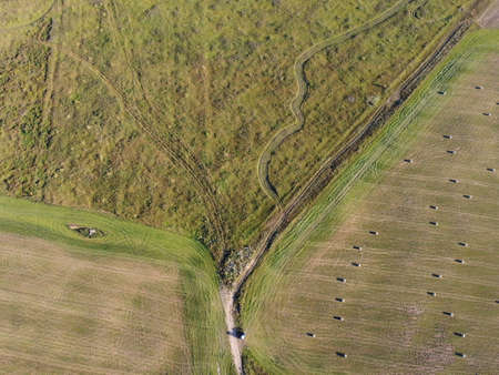 rolls of hay on the field aerial photoの写真素材