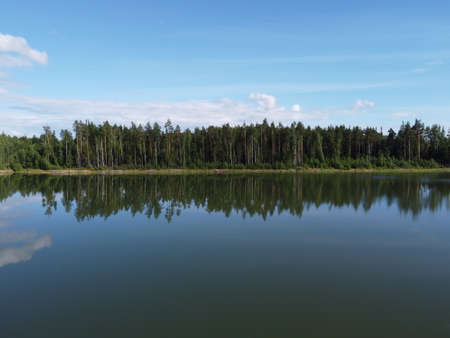 woodland on the shore of a reservoir on a summer day aerial photoの写真素材