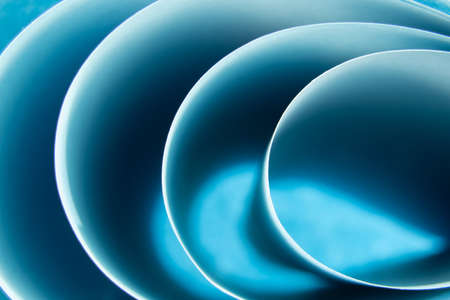 Abstract colored macro background, created with curved blue paper sheets. Curved lines and shapes and soft colors.の写真素材