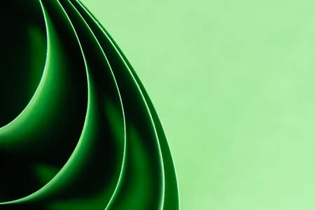 Abstract colored macro background, created with curved green paper sheets. Curved lines and shapes...