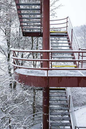 Exterior red metal stairs of an industrial building in Zurich in a snowy winterの写真素材