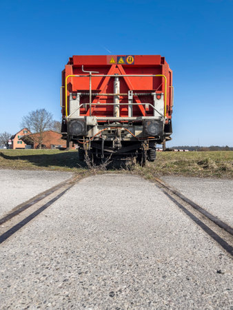 The last wagon of a standing train composition on a track in the middle of a meadowの写真素材