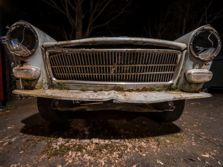 Night shot of the front mask of an abandoned decaying retro oldtimer french carの写真素材