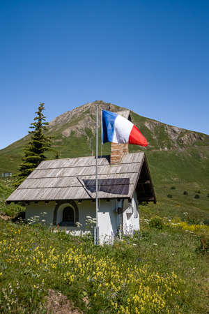 Col du Lautaret, France - July 7, 2020: French national flag hung before the holiday of July 14 at the mountain pass Col du Lautaretのeditorial素材