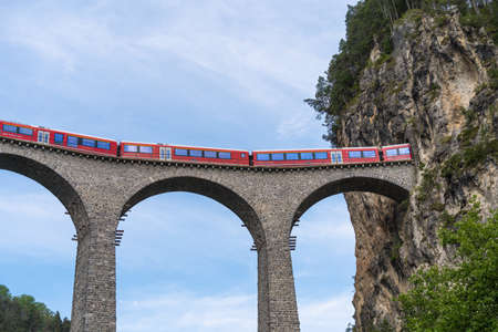 Filisur, Switzerland - June 17, 2021: A train is crossing a famous Landwasser viaduct nearby Filisur town in the swiss alpsのeditorial素材
