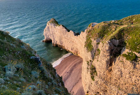 Etretat is best known for its chalk cliffs, including three natural arches and a pointed formation called Aiguille or the Needleの写真素材