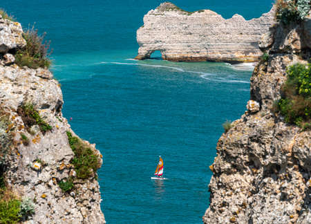 Etretat, France - July 31, 2021: The sailboat sails among the cliffs of Etretat on the Atlantic Ocean in Normandyのeditorial素材